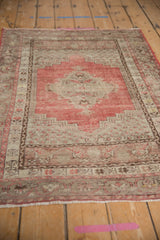 Distressed vintage Kula rug close-up: cherry red and beige field with visible wear to knot heads.