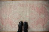 Distressed vintage Oushak runner with faded blush and antique ivory floral palmettes.