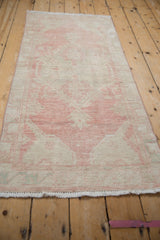 Distressed Oushak runner with worn floral palmettes and fringe in dusty blush.