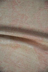 Distressed vintage Oushak rug pile detail, muted blush and ivory with visible wear.