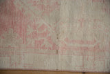 Distressed vintage Oushak rug's aged dusty blush pile and secured side.