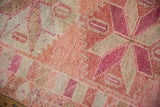 Short pile texture of a vintage Kurd rug's starburst medallion in pinks, fuchsia, and ivory.