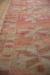 Short, even pile and abrashed texture of a vintage Kurd runner in pinks, reds, and ivory.