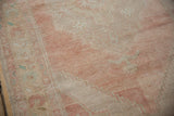 Vintage distressed Oushak rug detail: faded rose field, antique ivory stepped arabesque, soft turquoise.