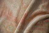 Distressed vintage Oushak rug with worn pile, faint foundation, and soft dusty rose patterns.