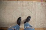 Distressed Oushak rug runner's faded ivory, pale pink, and green decorative texture.