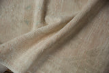 Textured pile of a vintage distressed Oushak rug runner, revealing ivory and faded pink.