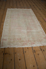 Vintage Oushak runner corner with distressed pale pink pattern, secure side cord, and fringe.