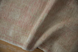 Hand-knotted distressed Oushak runner showing worn pile texture in soft pink, ivory, green gold.