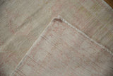 Vintage Distressed Oushak rug corner showing worn pale pink pile and tightly woven foundation.