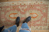 Distressed Oushak rug detail: pale dusty raspberry field, tangerine florals, hand-knotted texture.