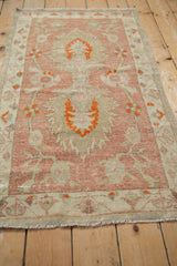 Distressed vintage Oushak rug runner pile with raspberry and tangerine palmette motifs.