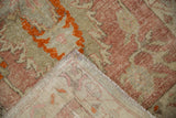 Vintage distressed Oushak runner's worn pile, showing hand-knotted reverse and fringed end.