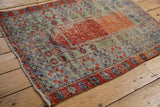 Abrashes on a vintage distressed Oushak rug: terracotta field, jade green floral border.