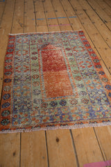 Distressed Oushak rug close-up: worn pile, visible foundation, faded terracotta, jade green, royal blue.