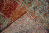 Distressed vintage Oushak rug corner, textural abrashes in terracotta, green, blue pile and woven reverse.