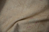 Distressed Oushak rug showing low pile texture and isolated areas of foundation.