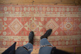 Distressed Kurd runner with geometric patterns, even wear, raspberry red, ivory, pale orange.