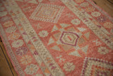 Distressed vintage Kurd runner pile with even wear, intact side selvage, and raspberry, ivory, orange patterns.