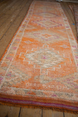 Textured distressed pile of vintage Kurd rug with tangerine, ivory, and purple geometric patterns.