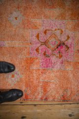 Distressed tangerine orange pile with fuchsia geometric patterns on a vintage Kurd runner.