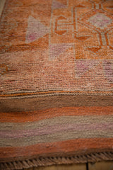 Distressed tangerine orange Kurd runner pile, showing varied texture and secure flatweave end.