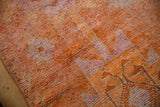 Distressed vintage Kurd rug pile in tangerine orange and soft fuchsia tones.