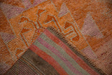 Textured tangerine and fuchsia pile with striped woven reverse of a distressed Kurd runner.