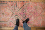 Distressed Kurd runner pile featuring pink, tangerine, and charcoal geometric patterns.
