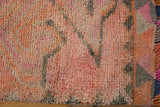 Distressed vintage Kurd rug runner pile in soft pink, charcoal, and tangerine hues.