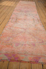 Textured distressed Kurd runner pile showing pink, orange, purple triangular border.
