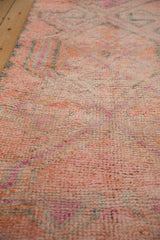 Distressed pile texture on vintage Kurd runner, with soft pink, orange, and gray tones.