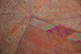 Distressed Kurd runner's textured pile in pink, orange, and gray, with geometric reverse.