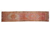 Vintage distressed Kurd runner, geometric starburst medallions, faded ruby red and tangerine.