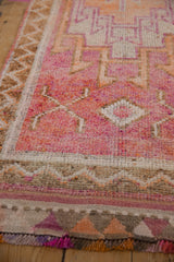 Distressed textured pile, geometric border, and fringe in ruby red, tangerine, brown.