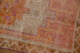 Distressed Kurd runner pile, showing tangerine orange and purple geometric stepped contours.
