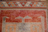 Distressed vintage Kurd rug border with geometric triangles in madder red, tangerine, and silver tones.