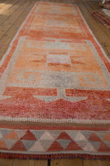 Distressed vintage Kurd runner end, displaying geometric flatweave border in madder root, tangerine, and silver.