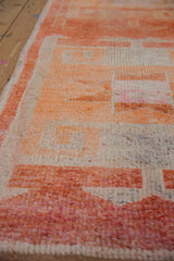 Worn pile of a distressed Kurd runner, showing primitive patterns in madder root red and tangerine.