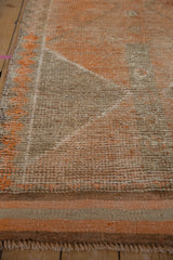 Short fringe and distressed texture of the vintage Kurd runner's end.