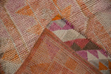 Distressed Kurd runner corner showing textured pile and tangerine, purple, brown geometric flatweave reverse.