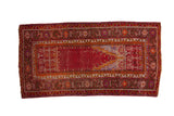Vintage Ghiordes runner with a worn red prayer design, saffron accents, and multiple geometric borders.