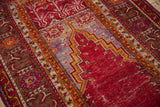 Visible knot heads and foundation within the cherry red and blue prayer niche of a Ghiordes rug.