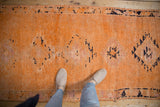 The nubby, distressed texture of a vintage Kurd runner in tangerine orange and charcoal.