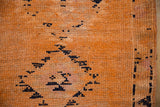 Distressed hand-knotted texture of the saffron orange Kurd rug showing exposed foundation.