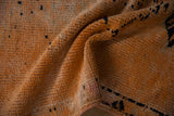 A soft fold reveals the low, hand-knotted pile of the distressed saffron orange Kurd runner.