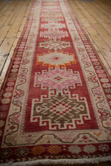 Distressed Kurd runner medallion, cochineal red, blush, ivory, and soft pile.