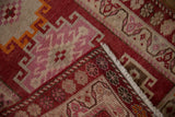 Distressed vintage Kurd runner corner, cochineal red, pink, ivory hook and latch, fringe.
