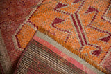Distressed vintage Kurd rug showing textured pile and striped foundation in raspberry, saffron, and wine.