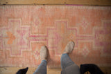 Distressed Kurd runner, featuring soft, short pile with faded pink and orange geometric motifs.
